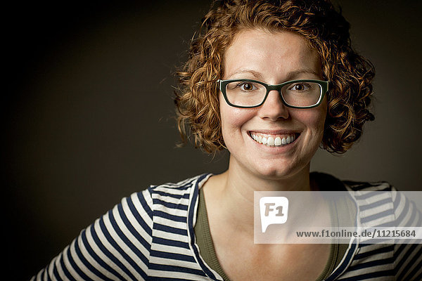 'Portrait of a young woman with curly red hair and eyeglasses; Regina  Saskatchewan  Canada'