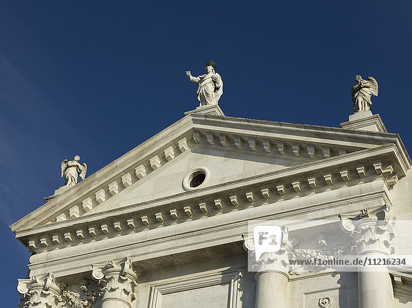'White facade of a building with statues of human figures along the roof; Venice  Italy'