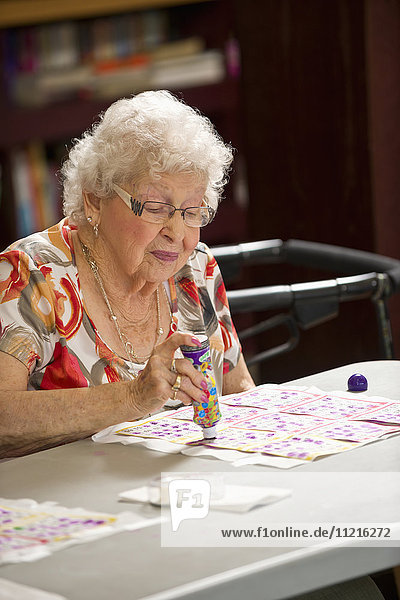 'A senior woman playing bingo; Devon,  Alberta,  Canada'