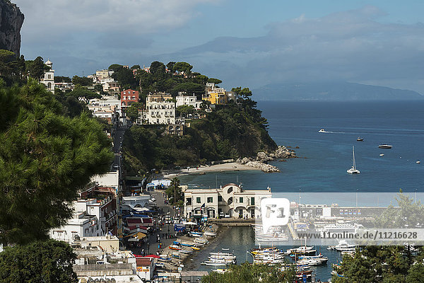 Blick auf bunte Gebäude auf den Klippen und am Wasser mit Booten im Hafen; Capri  Kampanien  Italien