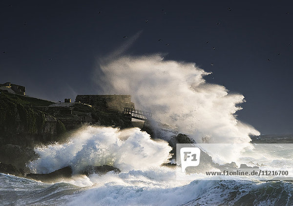 'Wave crashing into shore and splashing onto the land above the cliffs  Isla de la Palomas; Tarifa  Cadiz  Andalusia  Spain'