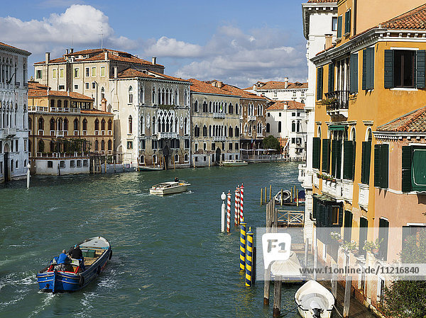 Boats in a canal and colourful buildings; Venice  Italy