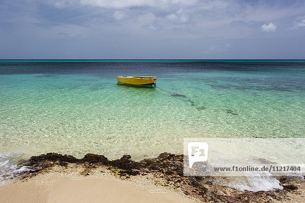 Ein einsames Boot im türkisfarbenen Wasser vor einer tropischen Insel; Frederiksted  St. Croix  Virgin Islands  Vereinigte Staaten von Amerika'.