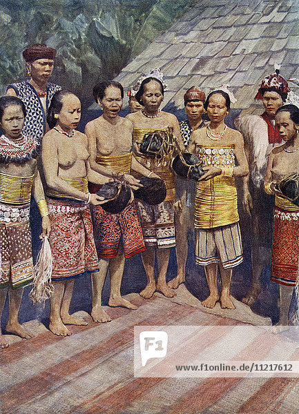 Dayak  Dyak- oder Dayuh-Frauen aus Borneo  Südostasien  tanzen mit menschlichen Köpfen. Einige Tage nach der Rückkehr von einer erfolgreichen Kopfjagd wurden die Köpfe  die von den toten Körpern abgehackt worden waren  ins Haus gebracht. Es folgte eine Zeit des Jubels  in der die Frauen die Köpfe an sich nahmen und sie nach fantastischen Tänzen neben die alten Köpfe hängten. Es wurde angenommen  dass die Anwesenheit der Köpfe im Haus die wohlwollenden Geister anlockt  die um sie herum leben. Aus Customs of The World  veröffentlicht ca. 1913.