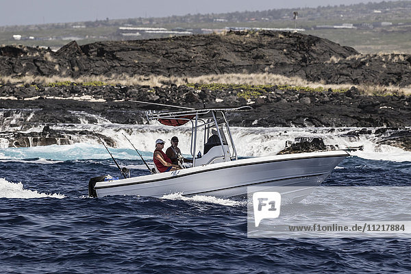 Sportfischerboot mit ausgefahrenen Angelruten beim Schleppangeln vor der Küste von Kona; Kona  Insel Hawaii  Hawaii  Vereinigte Staaten von Amerika