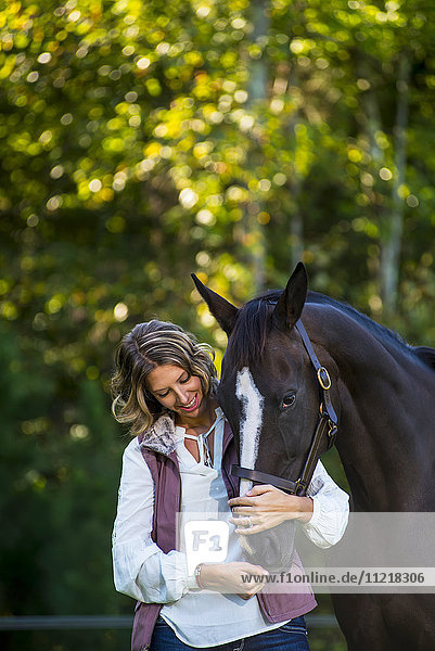 A teenage girl stands with her female thoroughbred horse at Folly Farm; Chapel Hill  North Carolina  United States of America