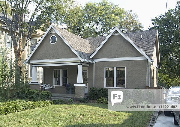 Front exterior of a one story bungalow with white trim at Nashville