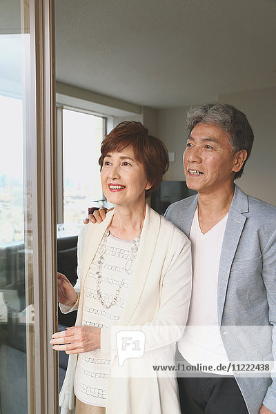 Modisches japanisches Seniorenpaar am Fenster