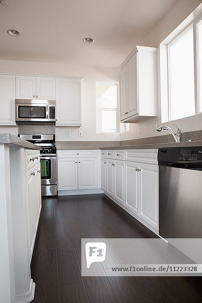 Blick auf eine Küche mit weißen Schränken zu Hause