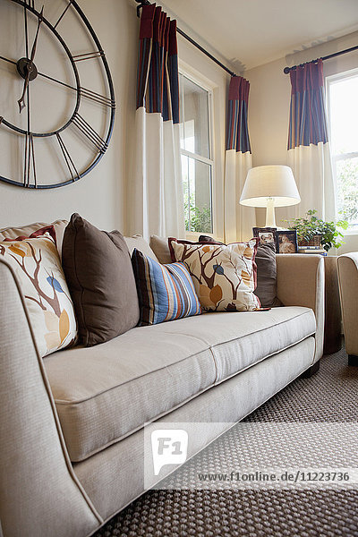 Couch mit großer Wanduhr im heimischen Wohnzimmer