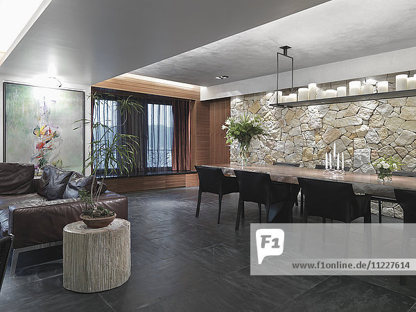 Moderner großer Raum mit Schieferfliesenboden und einer Steinwand