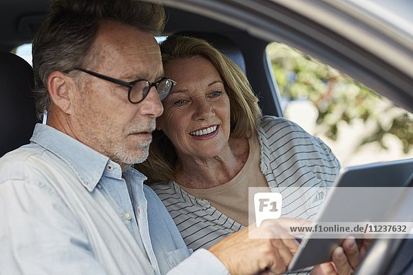 Couple in car with a digital tablet