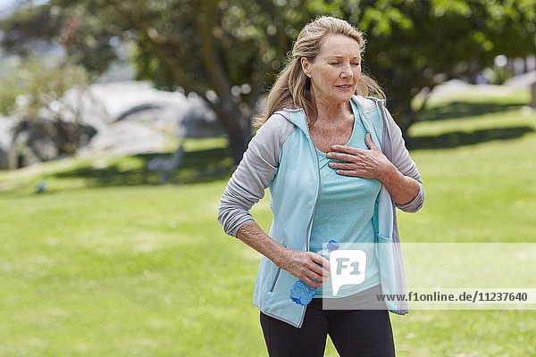 Senior woman holding chest in pain