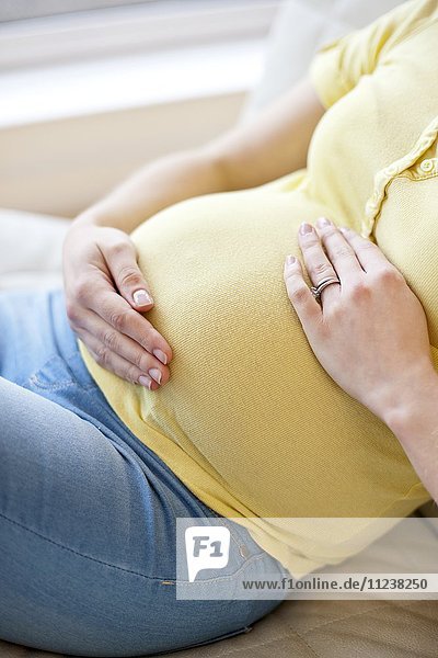 Schwangere Frau  die ihren Bauch berührt