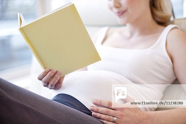 Schwangere Frau liest Buch