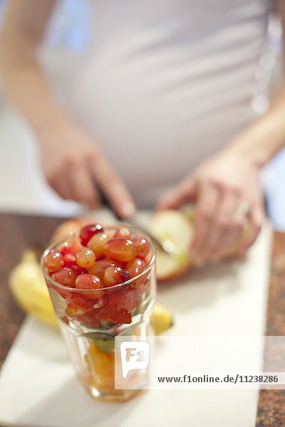 Schwangere Frau bereitet frisches Obst zu