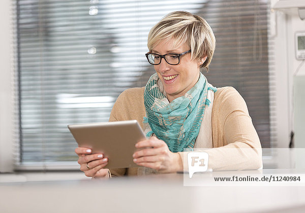 Blonde Frau mitTablet-PC