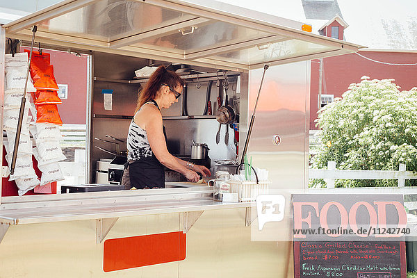 Frau bereitet Essen in der Küche eines Imbisswagens zu