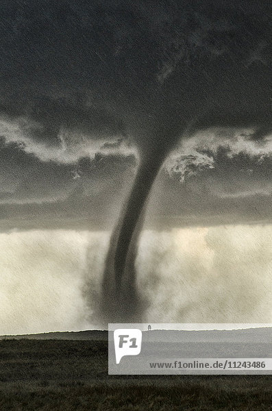 Ein von hinten beleuchteter Tornado  der bei Regen und Hagel Staub aufwirbelt  in der Ferne eine Windmühle  Wray  Colorado