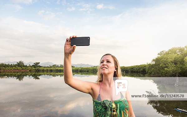 Junge Frau beim Smartphone-Selfie vor dem See  Gili Meno  Lombok  Indonesien