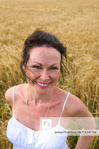 Porträt einer mittelgroßen erwachsenen Frau im Feld stehend  lächelnd