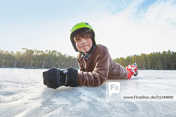 Porträt eines auf dem gefrorenen See liegenden Jungen  Gavle  Schweden