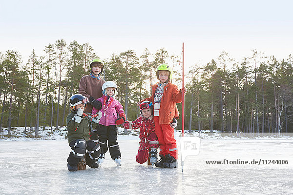 Porträt von Mädchen und Jungen mit Skihelmen auf dem zugefrorenen See  Gavle  Schweden
