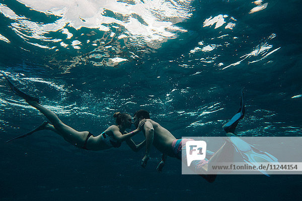 Underwater view of couple wearing flippers