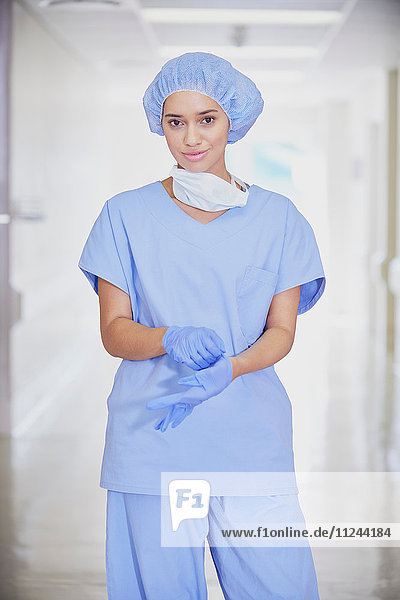 Portrait of mid adult female medic wearing scrubs in hospital corridor