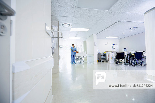 Mediziner schieben Krankenhausbett den Korridor entlang