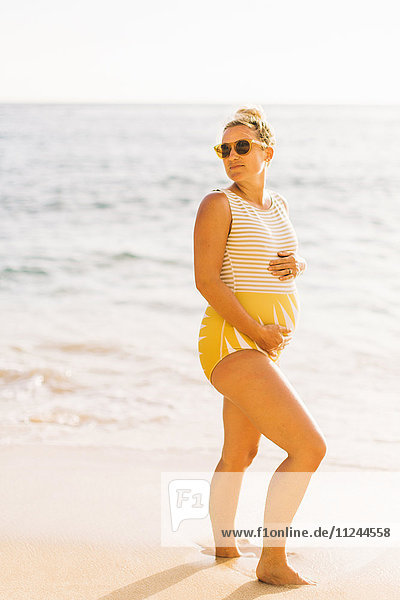 Schwangere Frau mittleren Alters im Badeanzug beim Rückblick vom Strand von Makua  Hawaii  USA