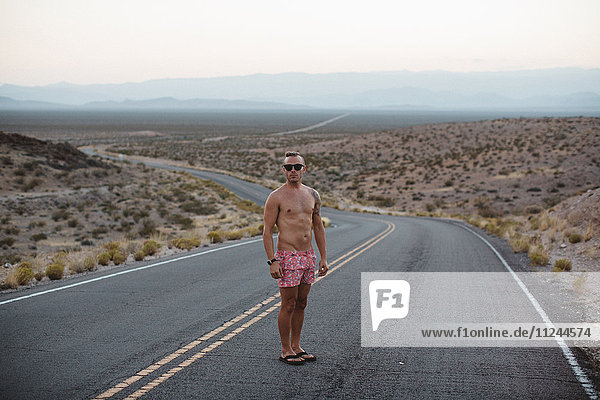 Man wearing and boxer shorts standing on rural road  Valley of Fire State Park  Nevada  USA