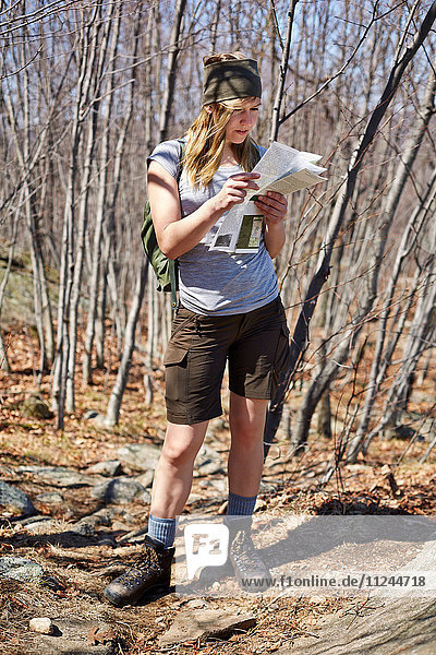 Woman hiker looking at map in Harriman State Park  New York State  USA