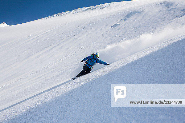 Männlicher Snowboarder beim Snowboarden den steilen Berg hinunter  Trient  Schweizer Alpen  Schweiz