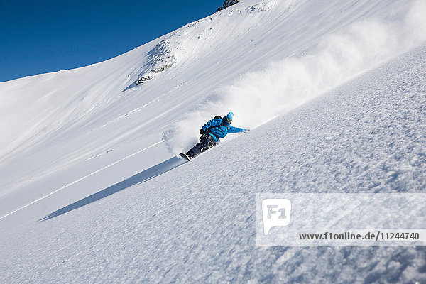 Männlicher Snowboarder rast den steilen Berg hinunter  Trient  Schweizer Alpen  Schweiz