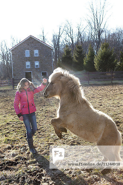 Junges Mädchen draußen  spielt mit Pony