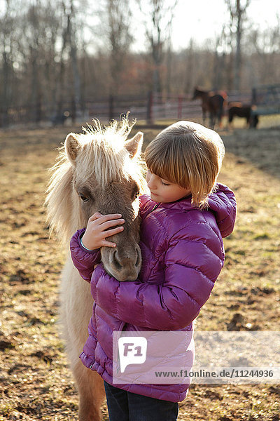 Junges Mädchen im Freien  umarmt Pony