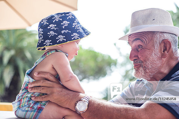 Grandfather making faces at baby boy