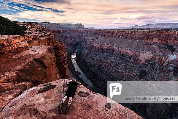 Mann auf Fels liegend  Blick auf Aussicht  Torroweap Overlook  Grand Canyon  Torroweap  Arizona  USA