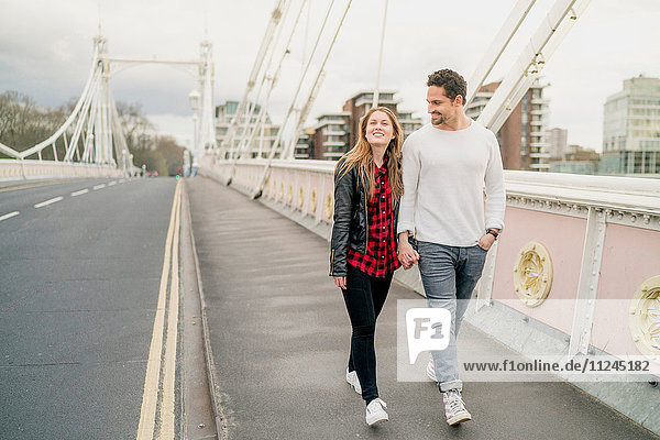 Junges glückliches Paar beim Spaziergang auf der Brücke  Battersea Park  London  UK