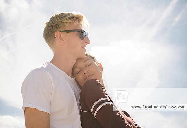 Woman and boyfriend against sunlit blue sky