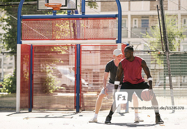 Zwei männliche Basketballspieler üben auf dem Basketballfeld
