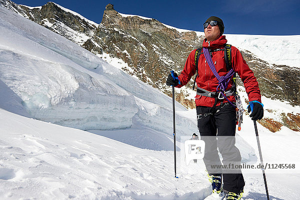 Mann Skitouren auf schneebedecktem Berg  Saas Fee  Schweiz