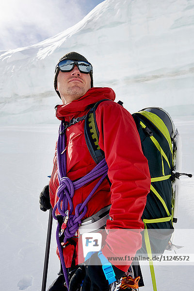 Porträt eines Mannes mit Bergsteigerausrüstung mit Blick in die Ferne