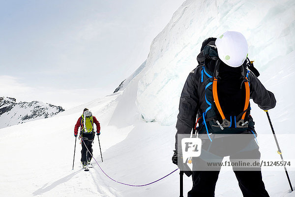 Rückansicht von Bergsteigern beim Skitourengehen auf schneebedecktem Berg,  Saas Fee,  Schweiz