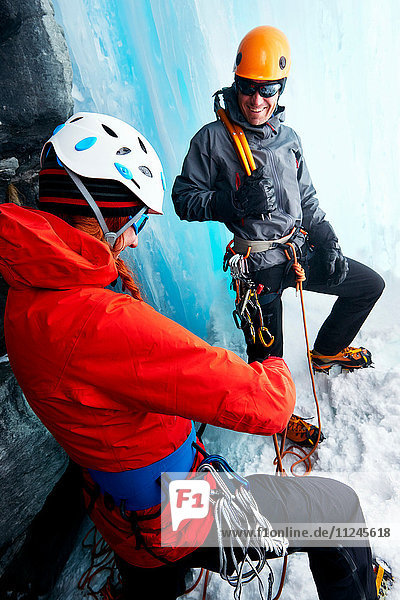 Eiskletterer in Eishöhle bereiten Kletterausrüstung vor