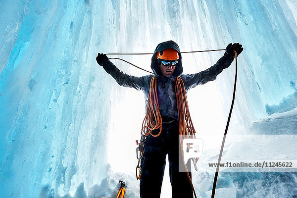 Mann in Eishöhle bereitet Kletterseil vor  Saas Fee  Schweiz