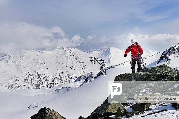 Mann auf der Spitze eines schneebedeckten Bergwurf-Kletterseils  Saas Fee  Schweiz