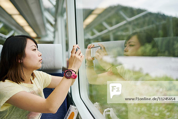 Weibliche Touristin fotografiert durch das Fenster eines Personenzuges  Chur  Schweiz