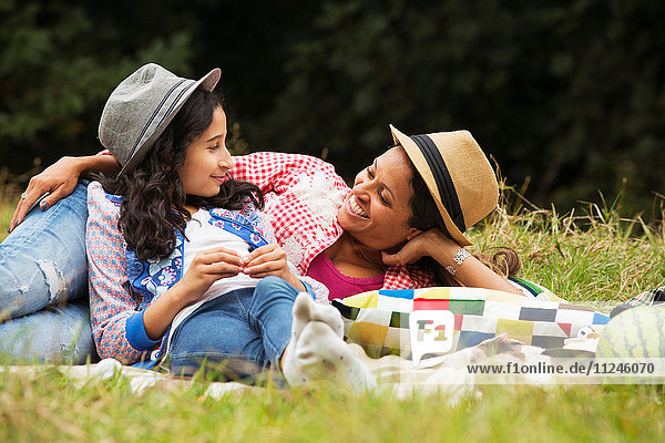 Mutter und Tochter entspannen sich im Freien  auf einer Picknickdecke liegend